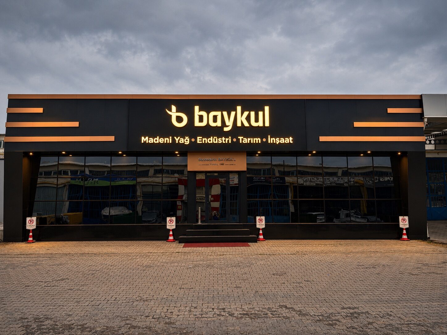 Baykul merkez binası, gece — aydınlatmalı tabela ve camlı ön cephe